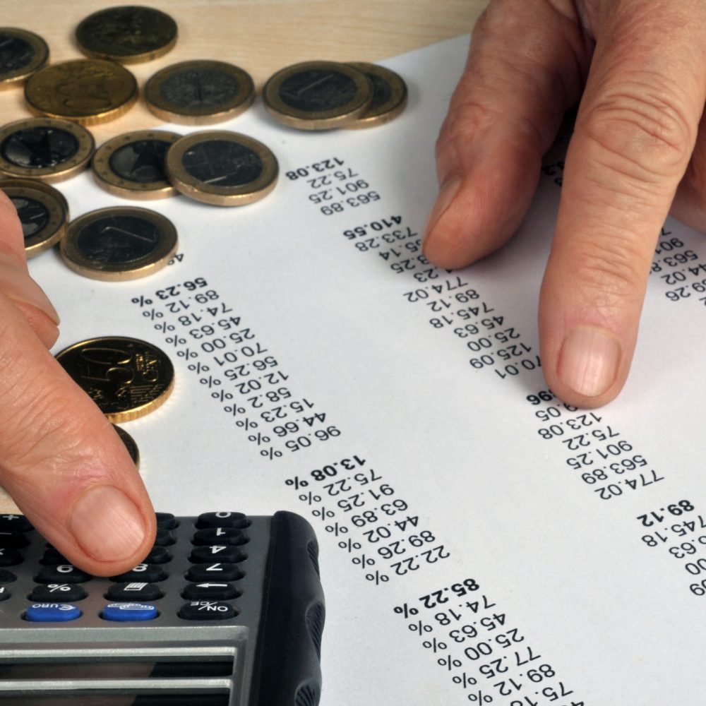 Cash and calculator on a listing Accounting concept with checking a list of numbers with a calculator